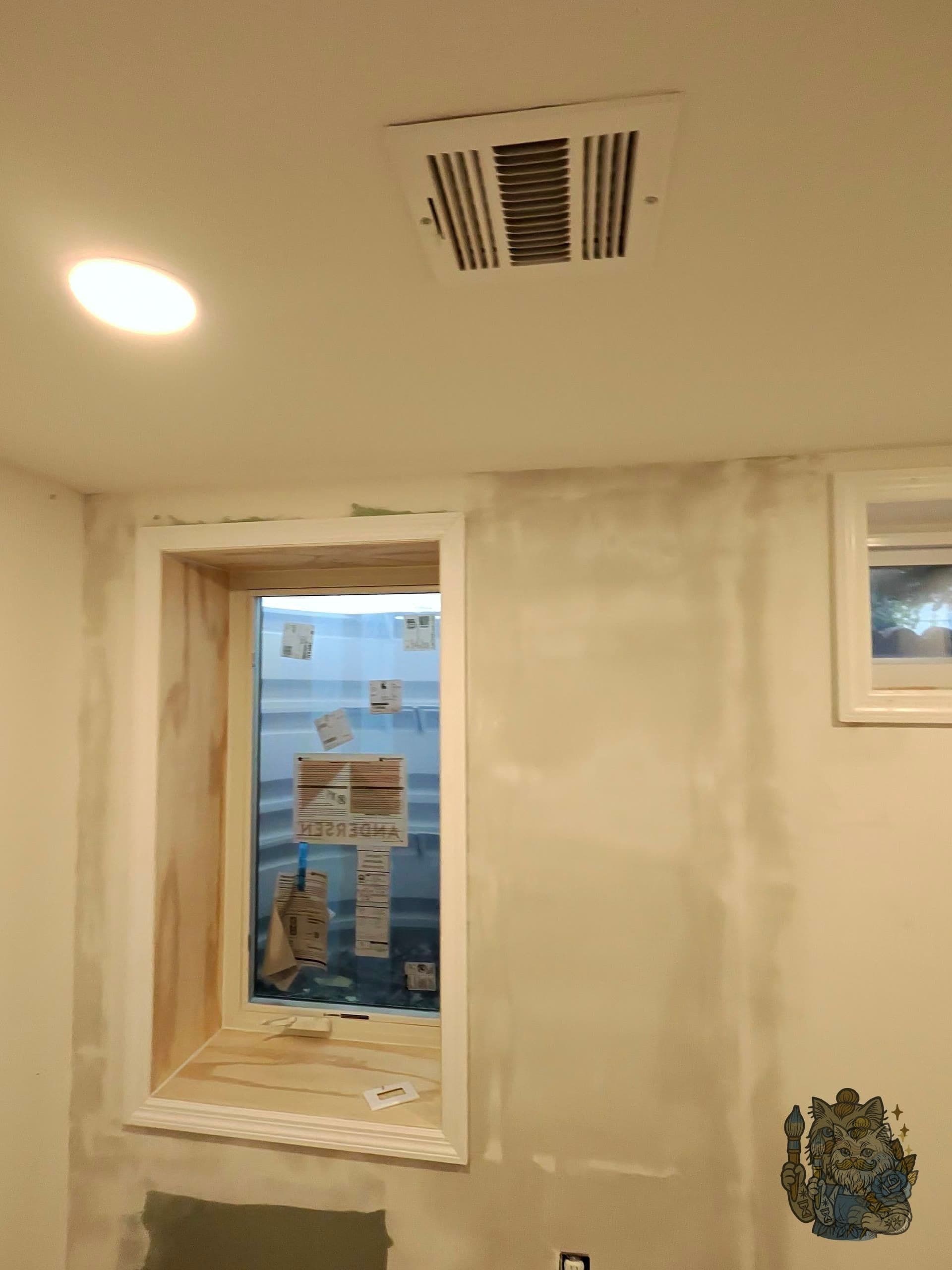 Wall after skimming — fresh skim coats around a window